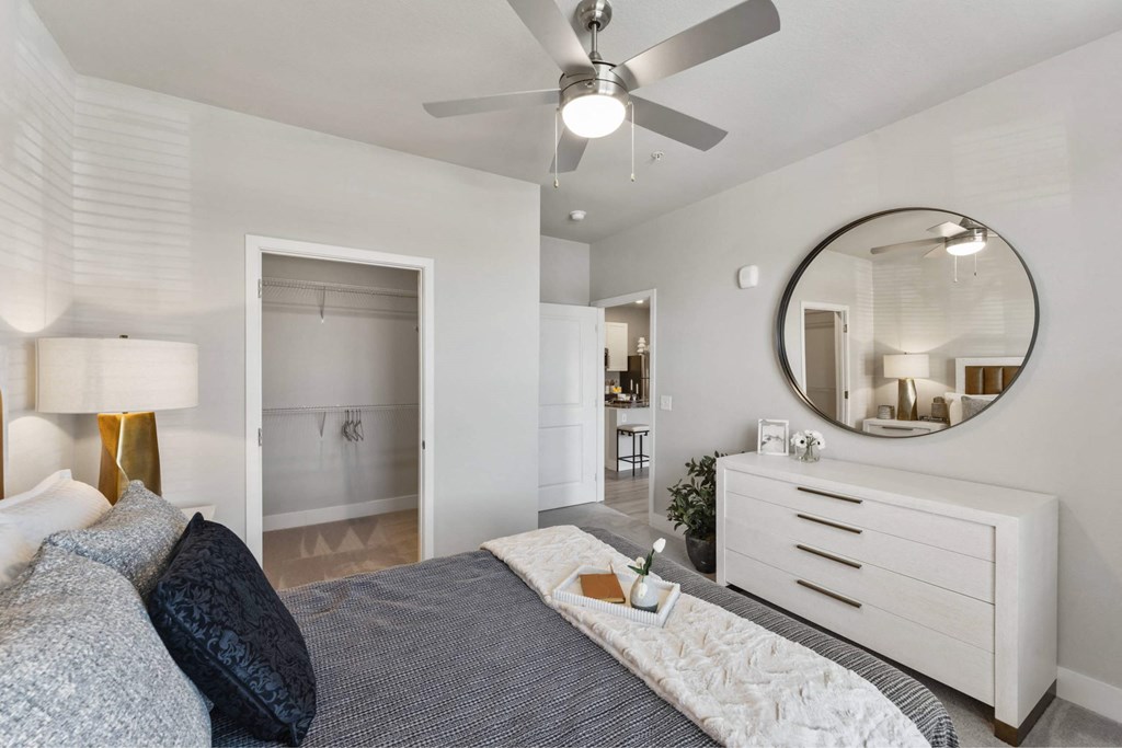 A bedroom with a bed, dresser, and mirror.