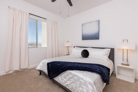 A bedroom with a large bed and a ceiling fan.