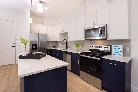 A kitchen with dark blue cabinets and a white countertop.