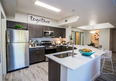 A modern kitchen with a white countertop and a refrigerator with a stainless steel finish.