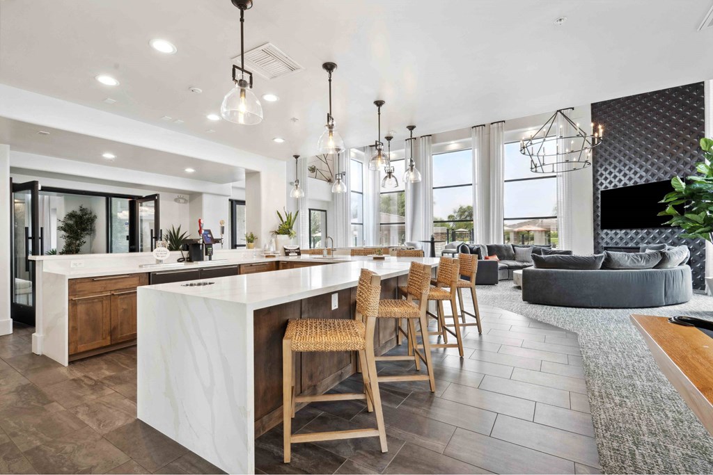 A modern kitchen with a white island and wooden chairs.