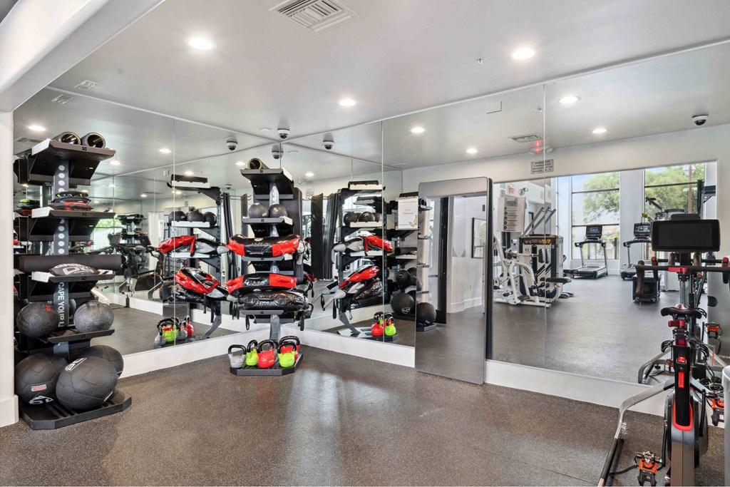 A gym with a variety of exercise equipment including treadmills, weights, and exercise bikes.