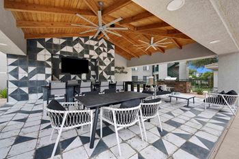 A patio with a table and chairs and a TV.