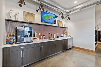 a bar area with a coffee machine and a tv on the wall