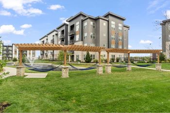 a park with hammocks in front of an apartment building