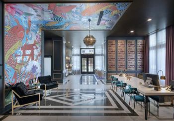 A room with a large mural on the wall and a long table with chairs.