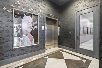 the lobby of a building with a poster on the wall and two doors