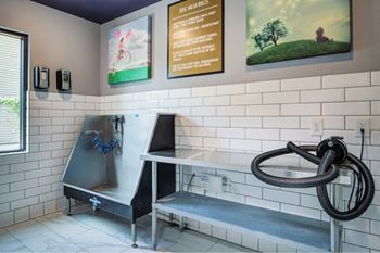 A cleaning station with a hose and a sign on the wall.