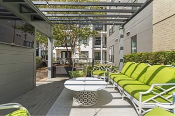 a patio with green furniture and a white table
