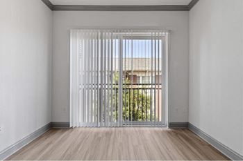 a living room with white walls and a large window with white blinds