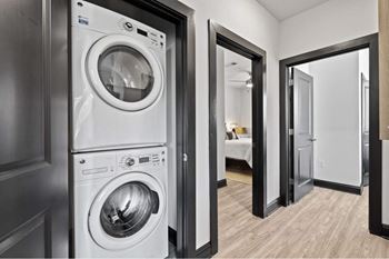a white washer and dryer in a room with a door