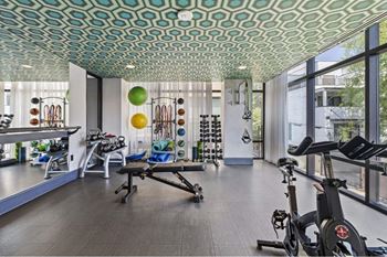a workout room with exercise equipment and large windows