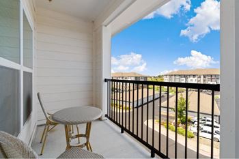 a balcony with a table and two chairs and a view of a building