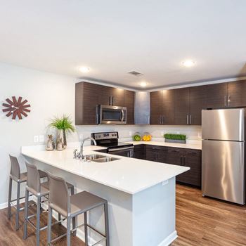 A modern kitchen with a white island and stainless steel appliances.