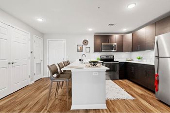 A kitchen with a white island and brown cabinets.