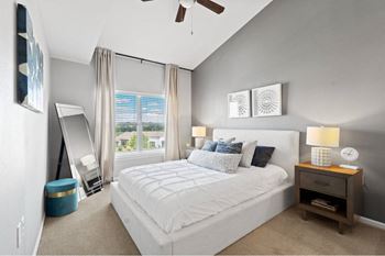 a bedroom with a bed and a window and a ceiling fan