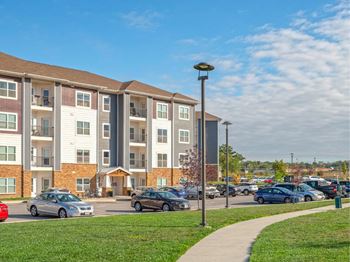 Apartment building with cars parked in front.