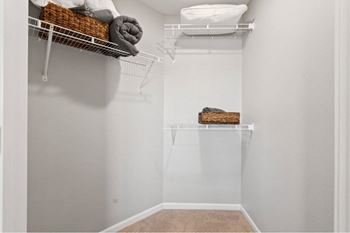 our spacious walk in closet with shelves and hooks for clothes and towels