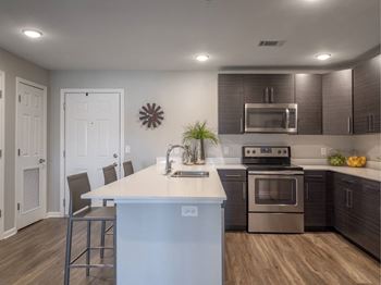a kitchen with a white island and a stainless steel refrigerator
