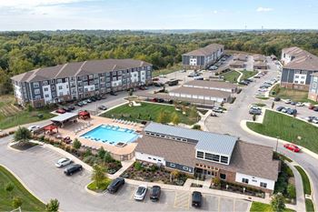 An aerial view of a resort with a swimming pool and a parking lot.