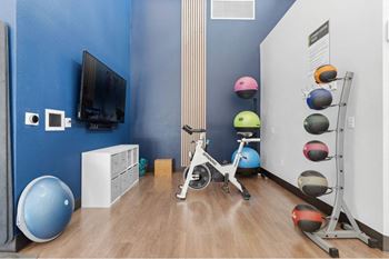 a workout room with exercise equipment and a tv