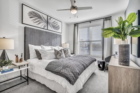 A bedroom with a large bed and a ceiling fan.
