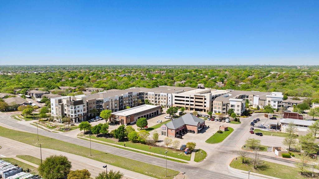 A view of a residential area with apartment buildings and a parking lot.