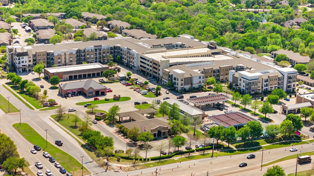 A large apartment complex with a parking lot in front.