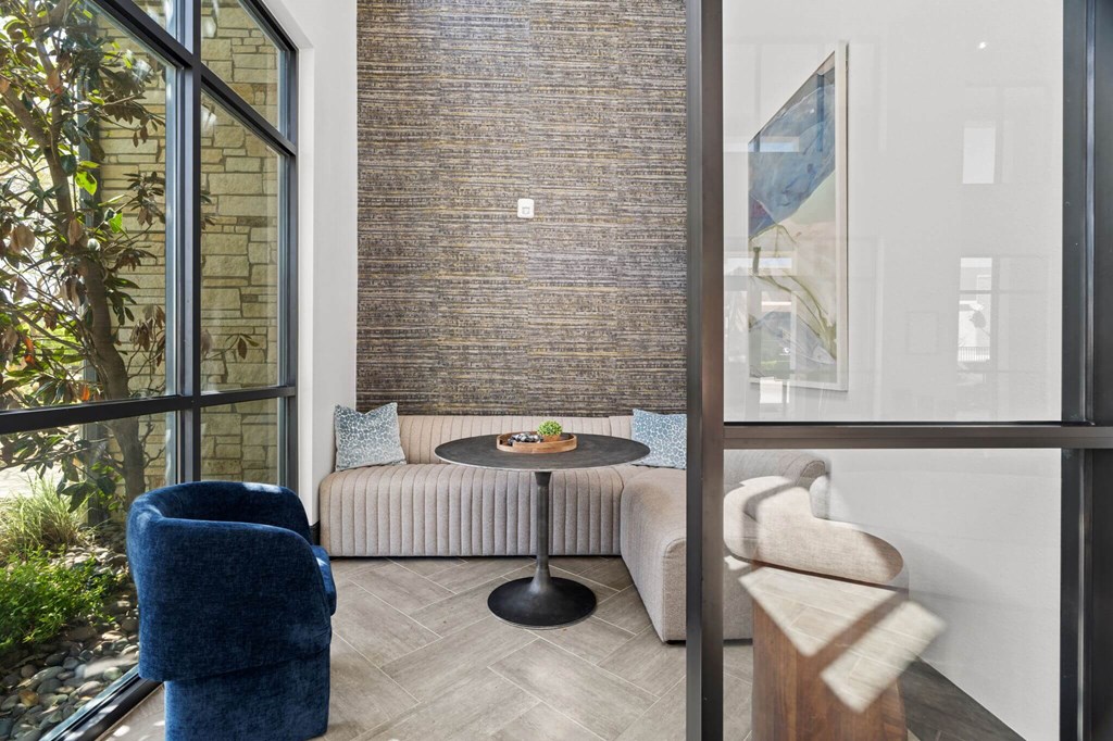 A living room with a blue chair and a round table.