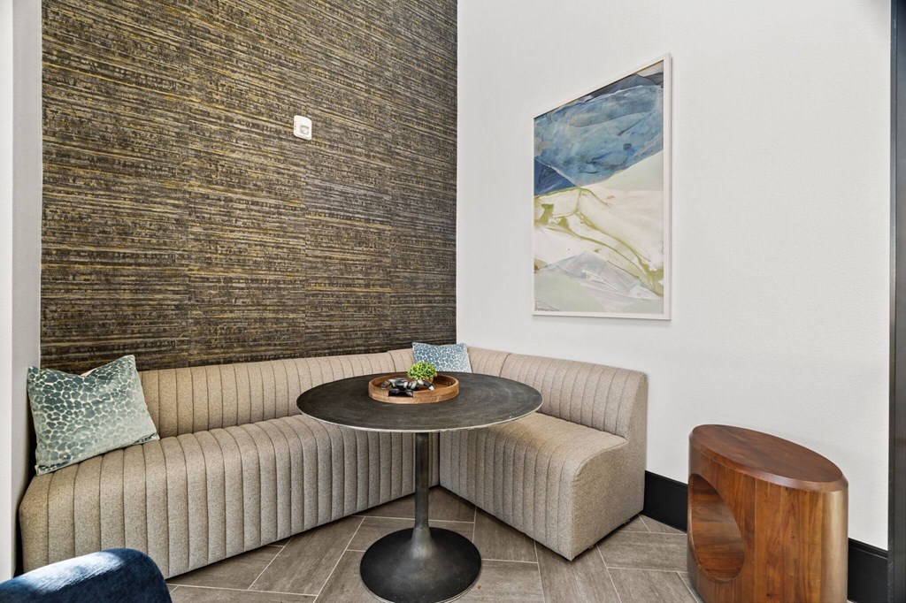 A round table with a plant on it sits between two couches in a room.