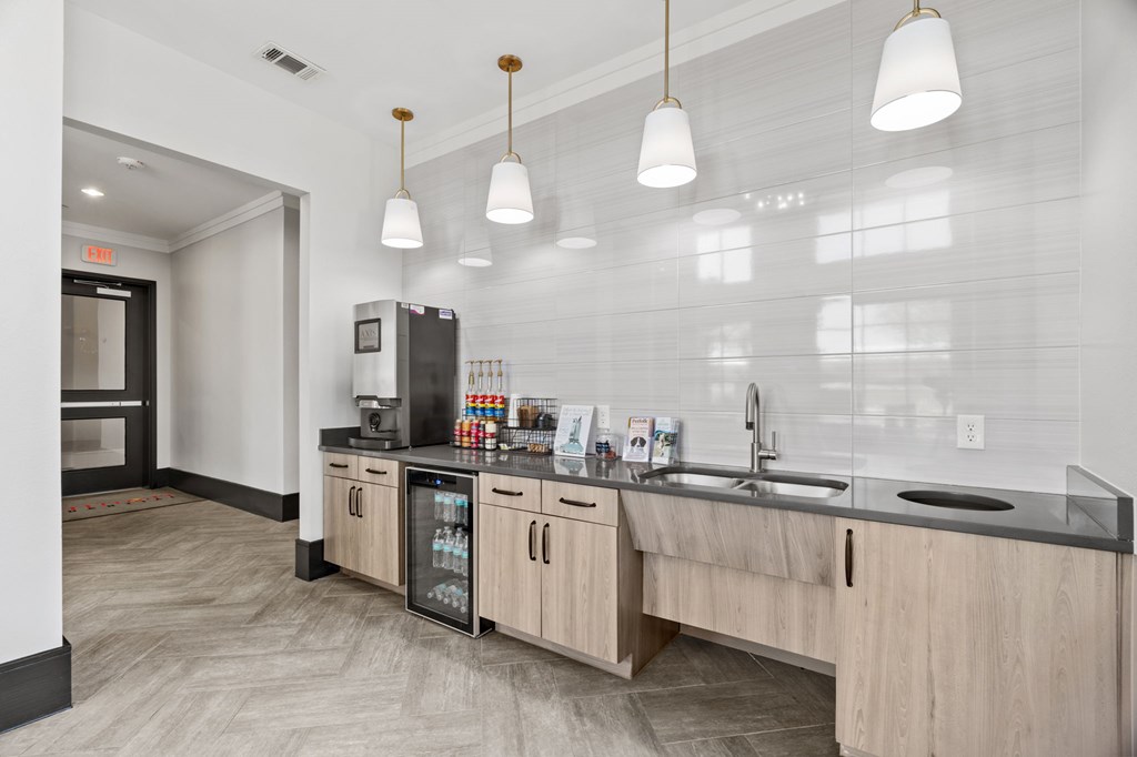 A kitchen with a refrigerator, sink, and cabinets.