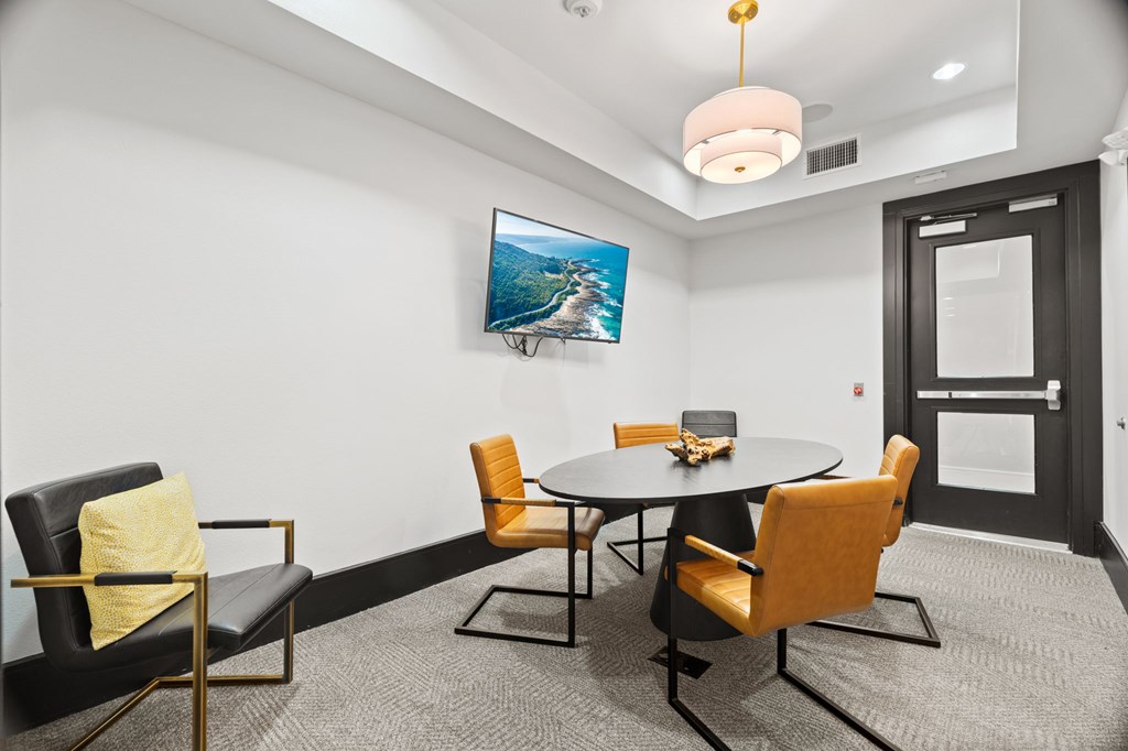 A modern dining room with a round table and chairs.