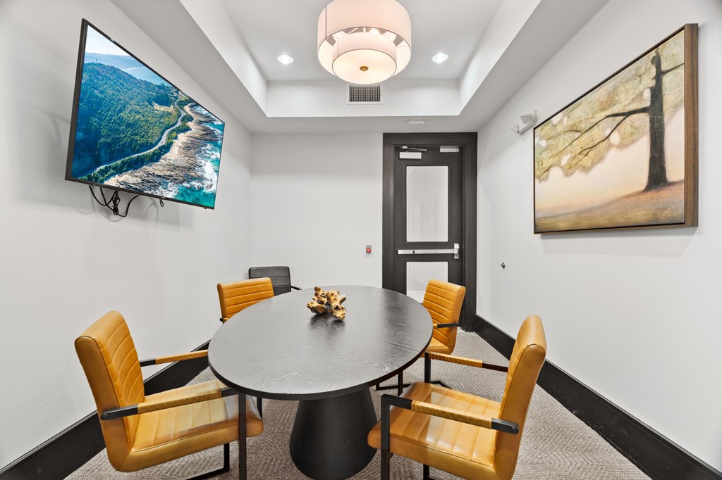 A conference room with a large table and chairs.