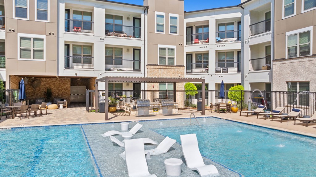 A swimming pool in front of apartment buildings.