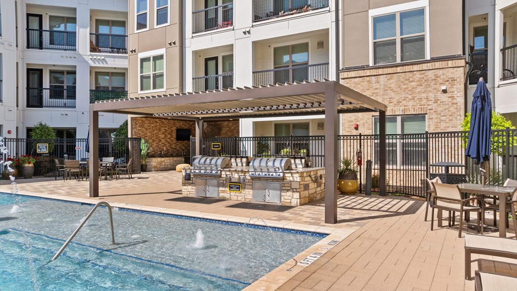 A pool area with a hot tub and a building in the background.