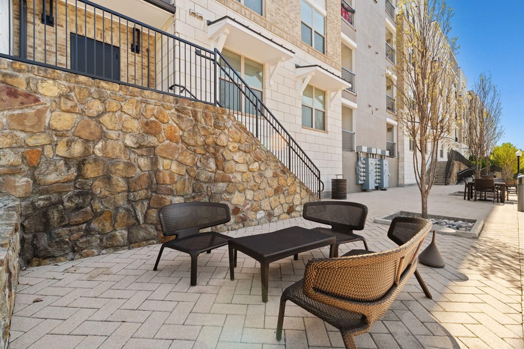 A patio with a table and chairs is in front of a building.