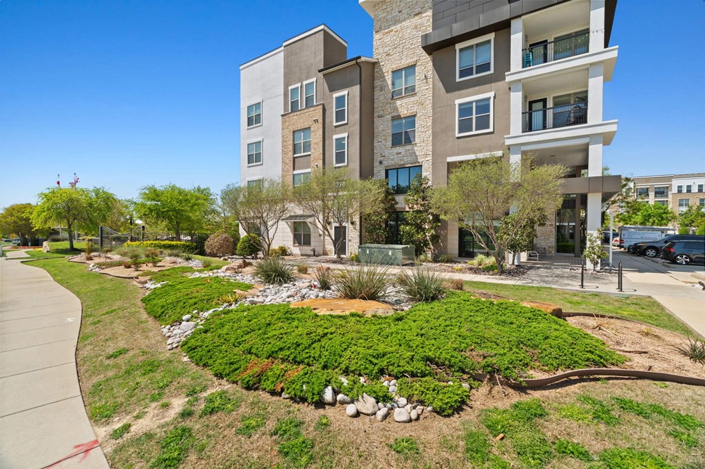A modern building with a landscaped garden in front.