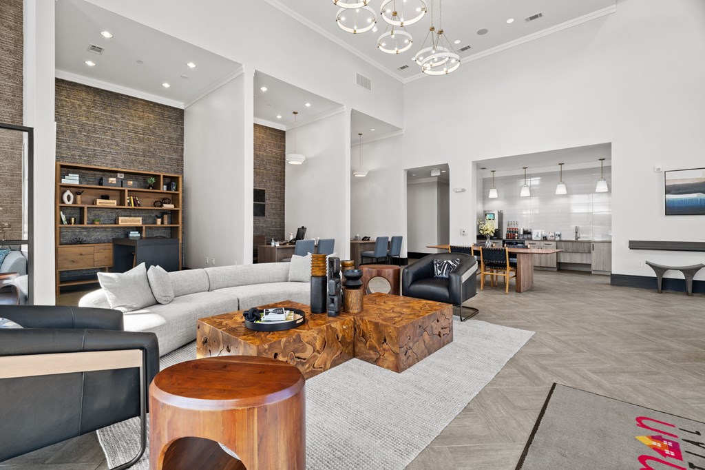 A modern living room with a wooden coffee table and a black leather couch.