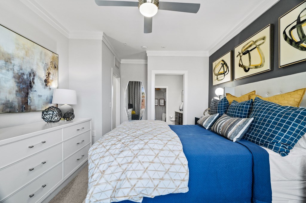 A bedroom with a large bed and a ceiling fan.