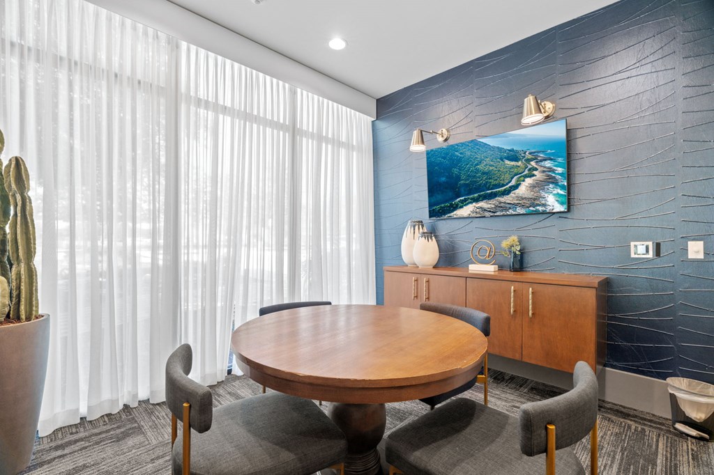 A conference room with a wooden table surrounded by chairs.