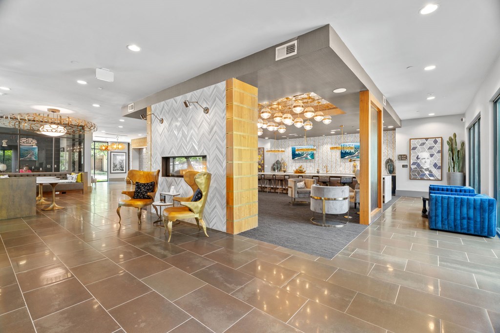 A spacious lobby with a variety of seating options and a large chandelier.