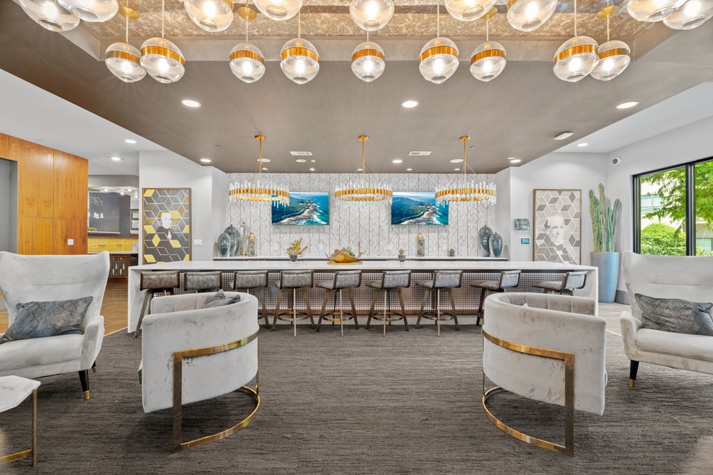 A modern living room with a grey carpet and white furniture.