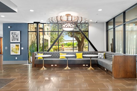 A modern living room with a grey sofa and a large window.