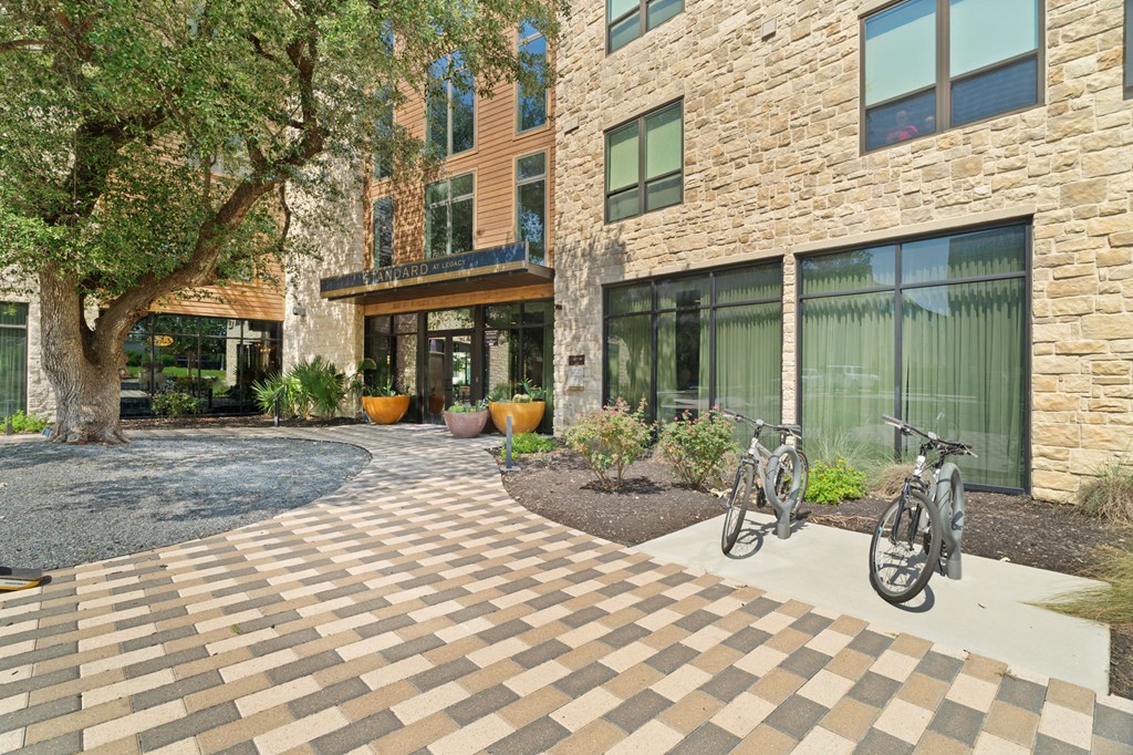 A courtyard with a brick patterned floor and a bicycle.