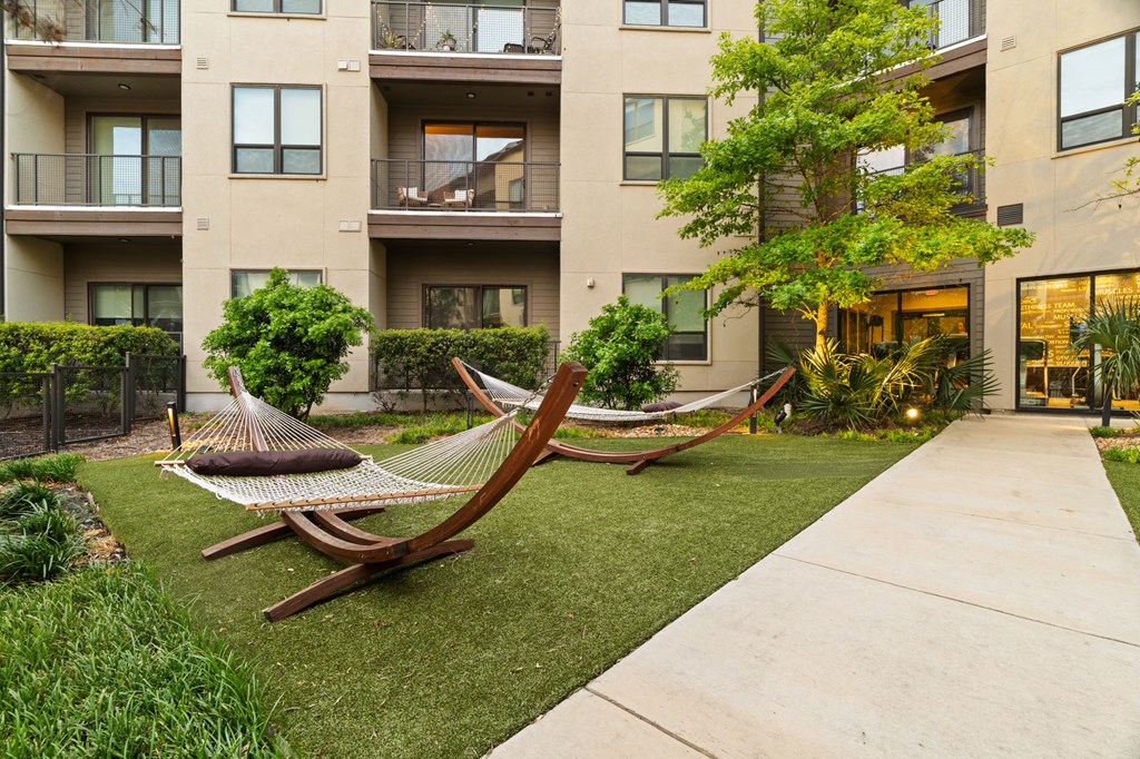 A hammock is placed in the front yard of a building.