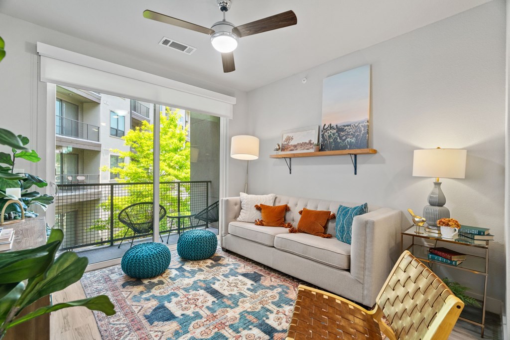 A living room with a couch, a chair, a rug, and a painting on the wall.