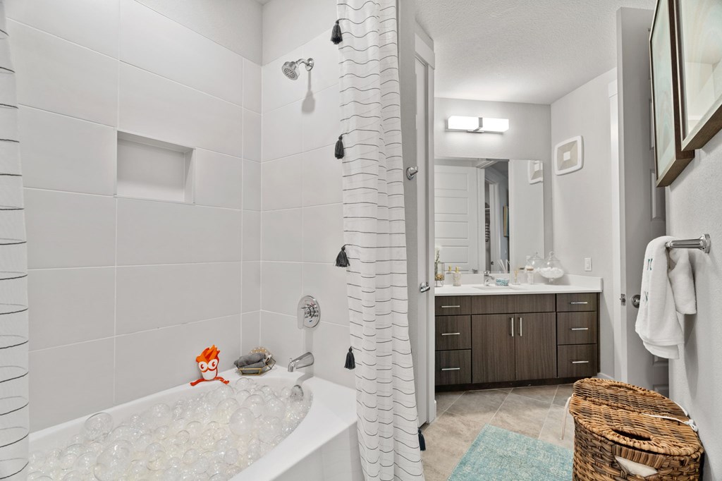 A bathroom with a white tub and a shower with a glass door.
