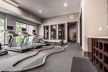 A gym with treadmills, exercise bikes, and a rowing machine.