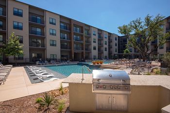 A pool and hot tub area in front of apartment buildings.