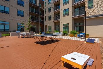 A wooden table is in the middle of a wooden deck.